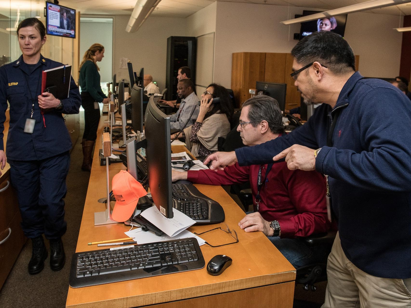 man in blue jacket using computer